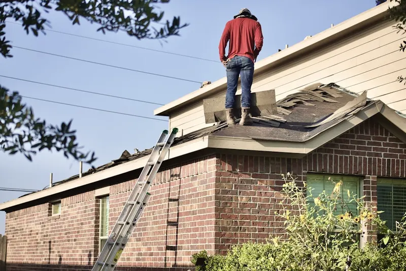 Professional roofer working on a residential roof in Westacres